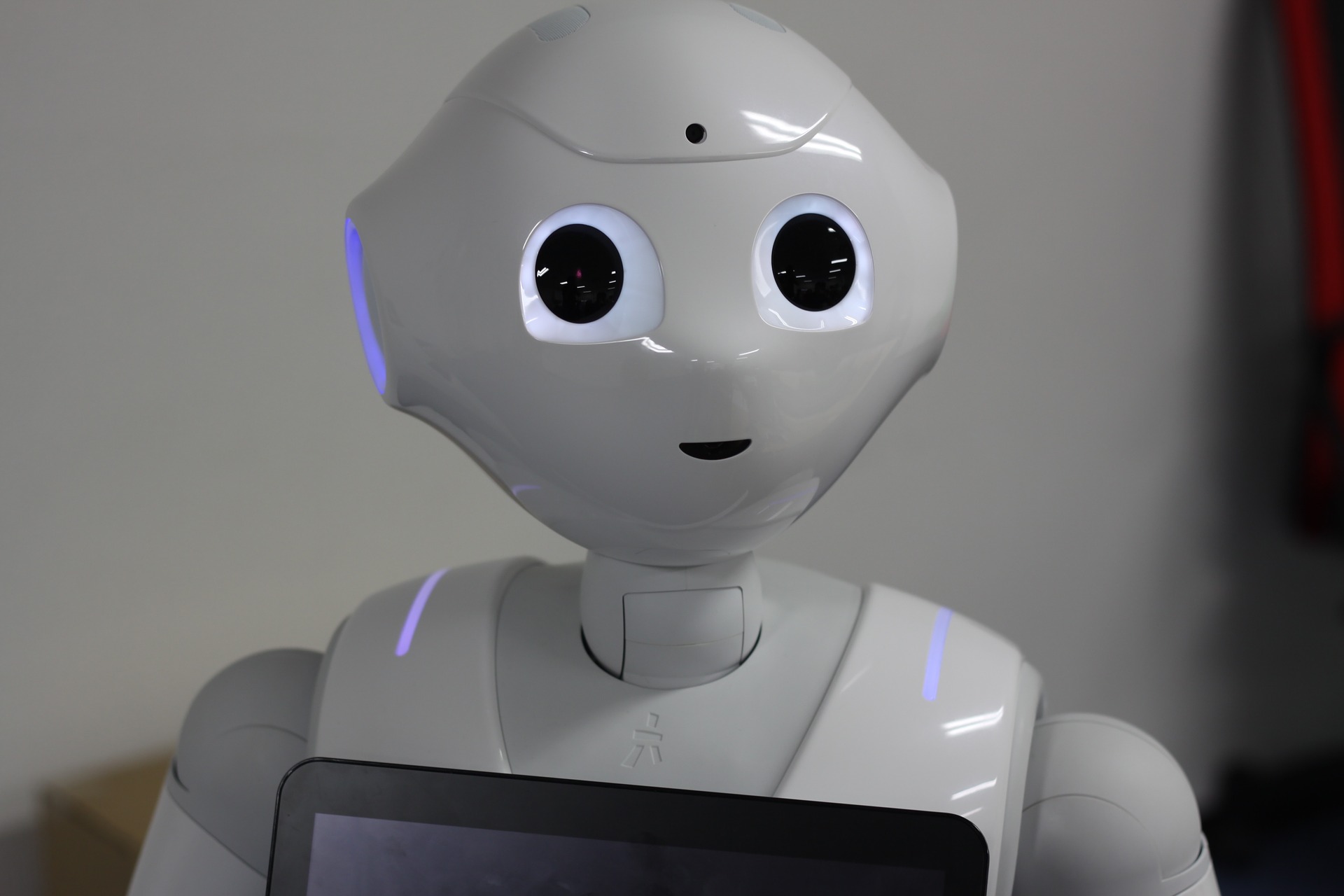 Bild des Roboters Pepper. Er ist weiß, hat ein "Gesicht" mit großen dunklen Augen.