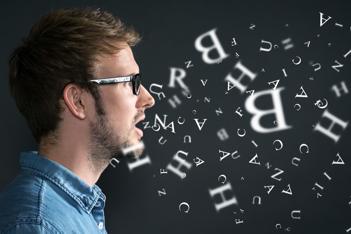 Eine Person spricht und aus ihrem Mund fliegen Buchstaben.