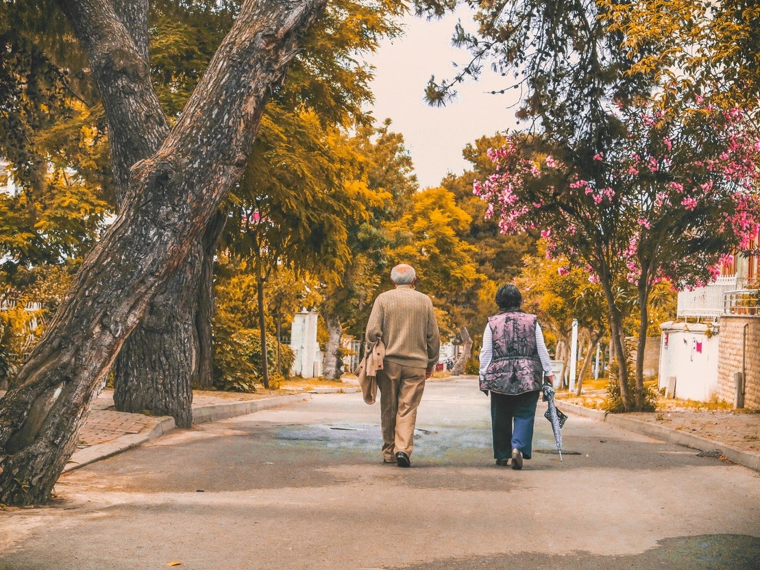 Zwei Senior*innen bei einem Herbstspaziergang.