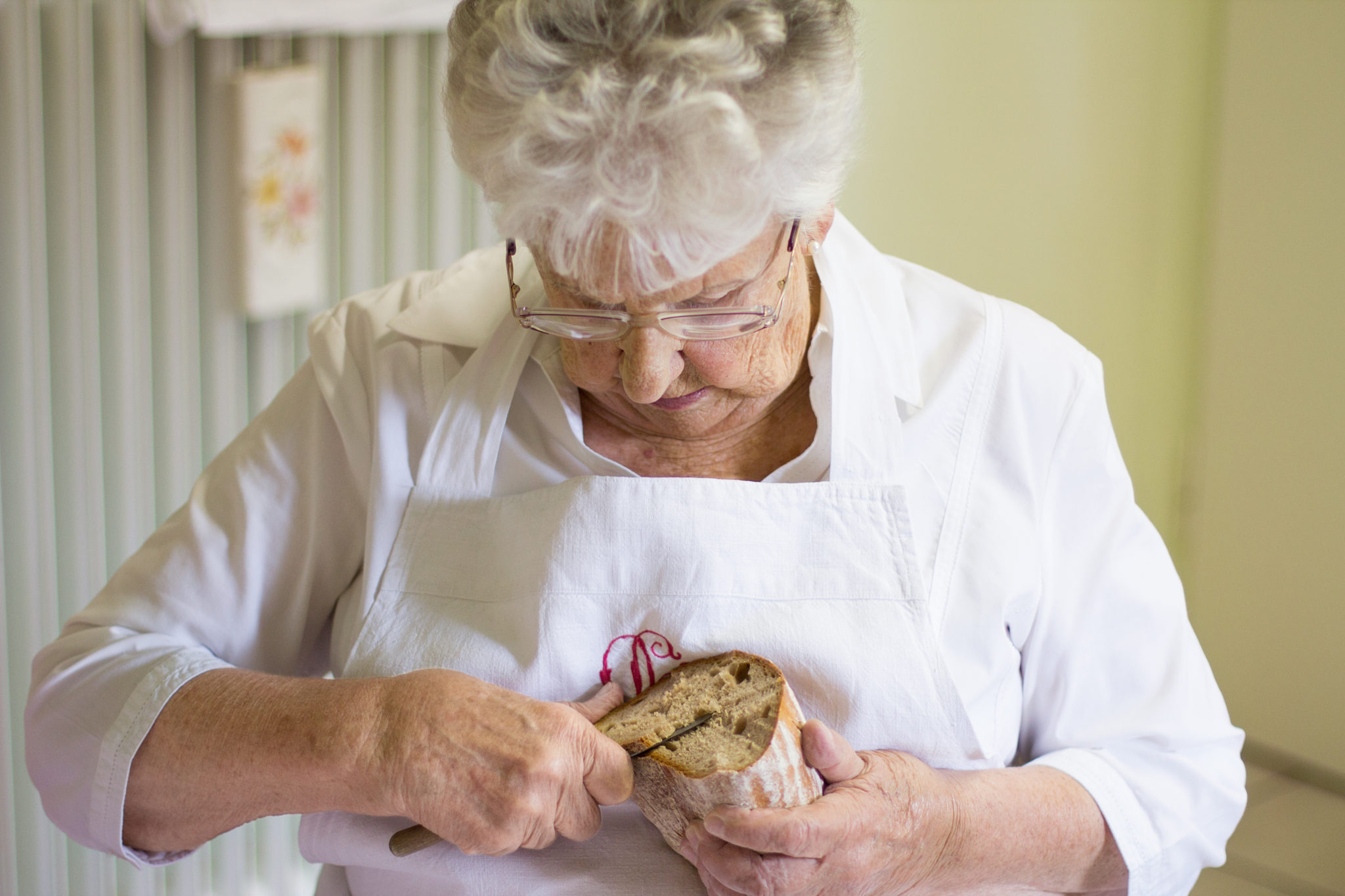 Eine Frau schneidet Brot mit einem Messer