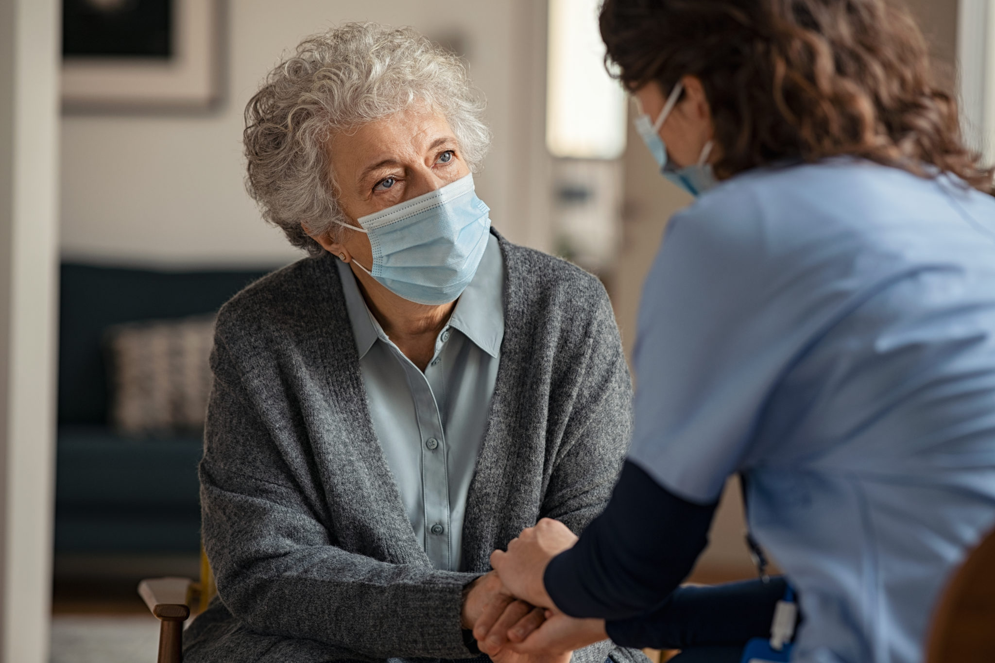 Eine Seniorin wird in einer Pflegeeinrichtung besucht.