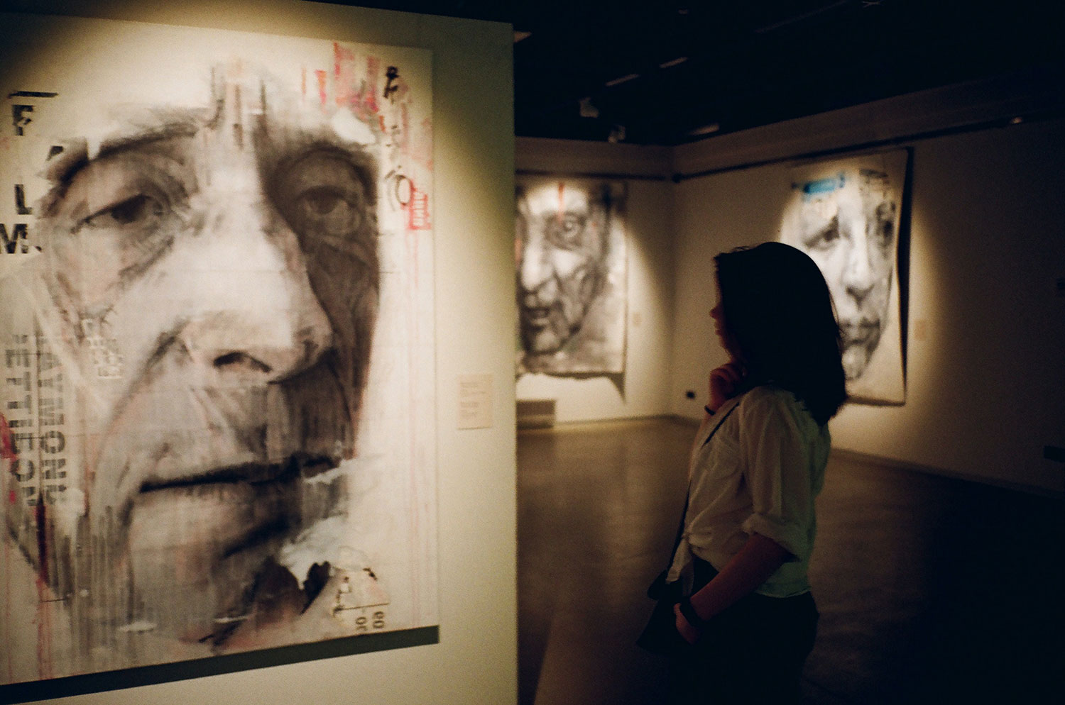 Das Bild zeigt eine Frau im Museum, die das Porträt eines älteren Mannes anschaut.