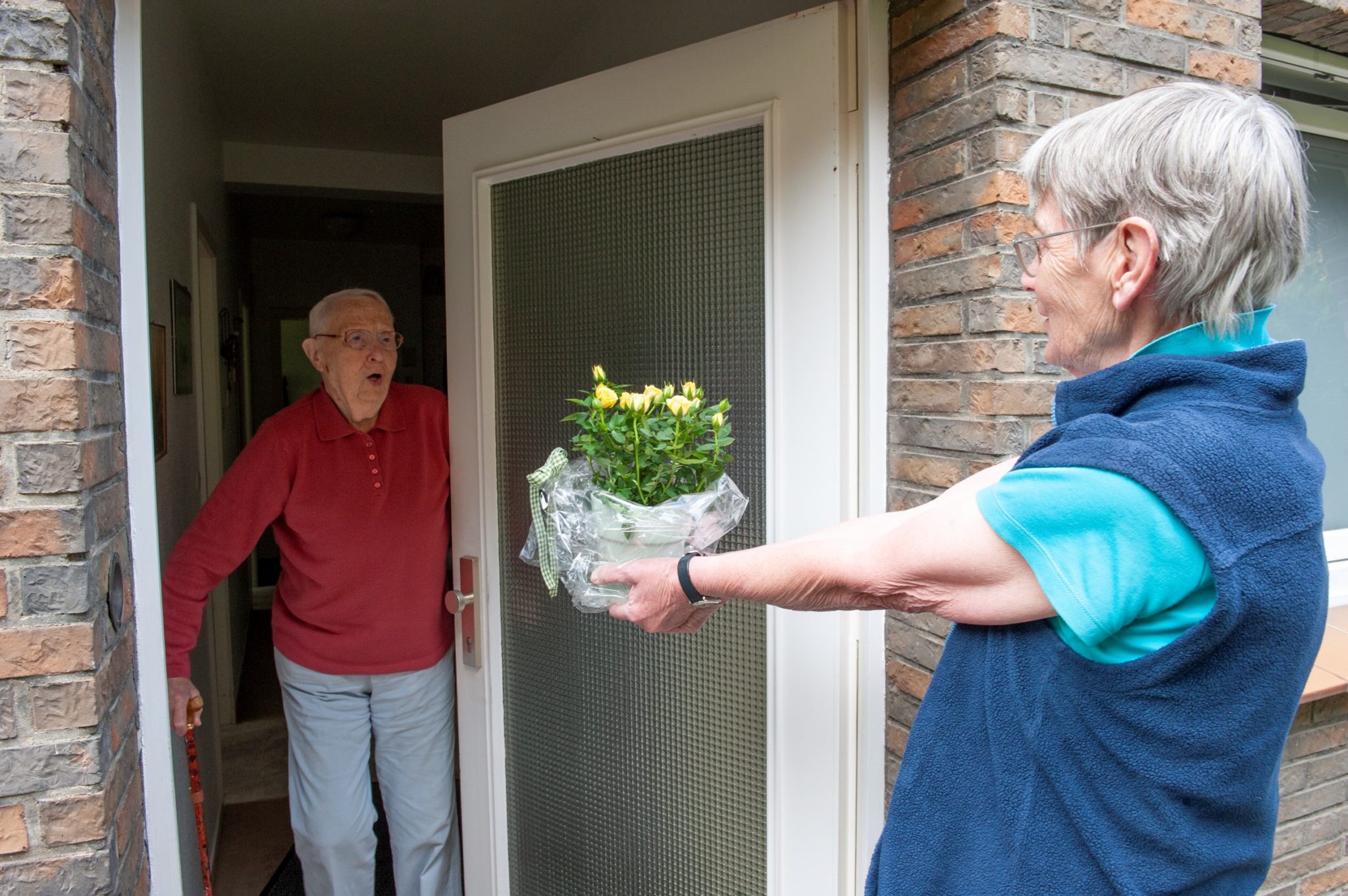 Einem Pflegenden Angehörigen werden Blumen überreicht.