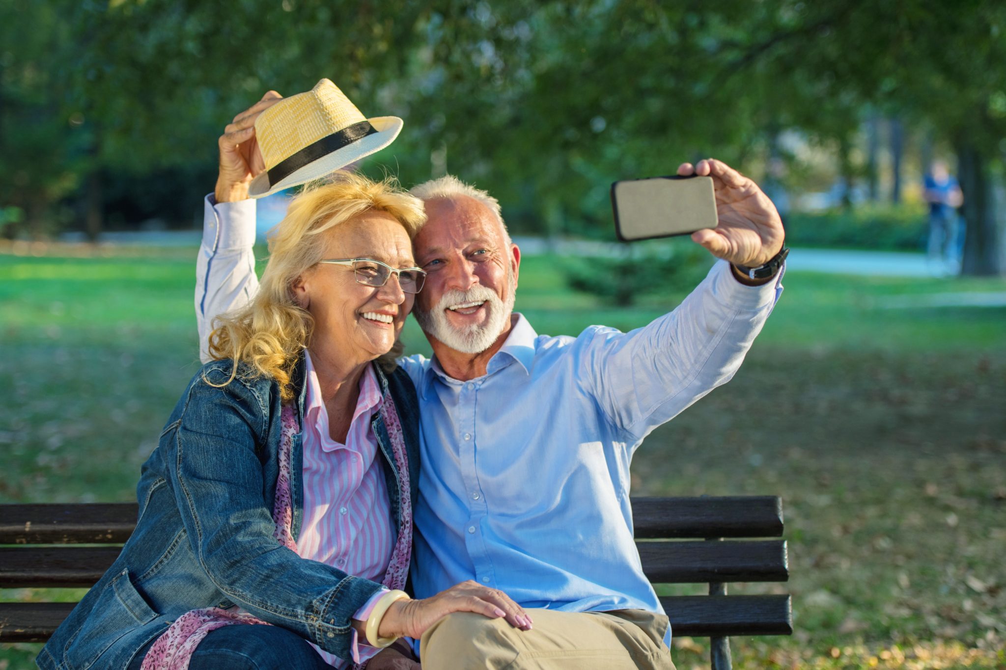 Paar sitzt auf einer Bank und macht ein Selfie.