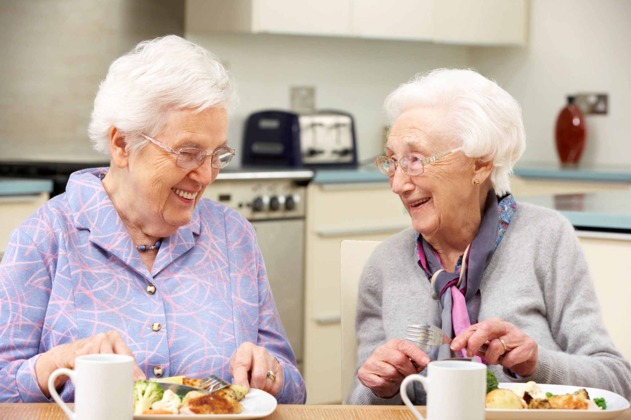 Zwei Seniorinnen essen gemeinsam zu Mittag.