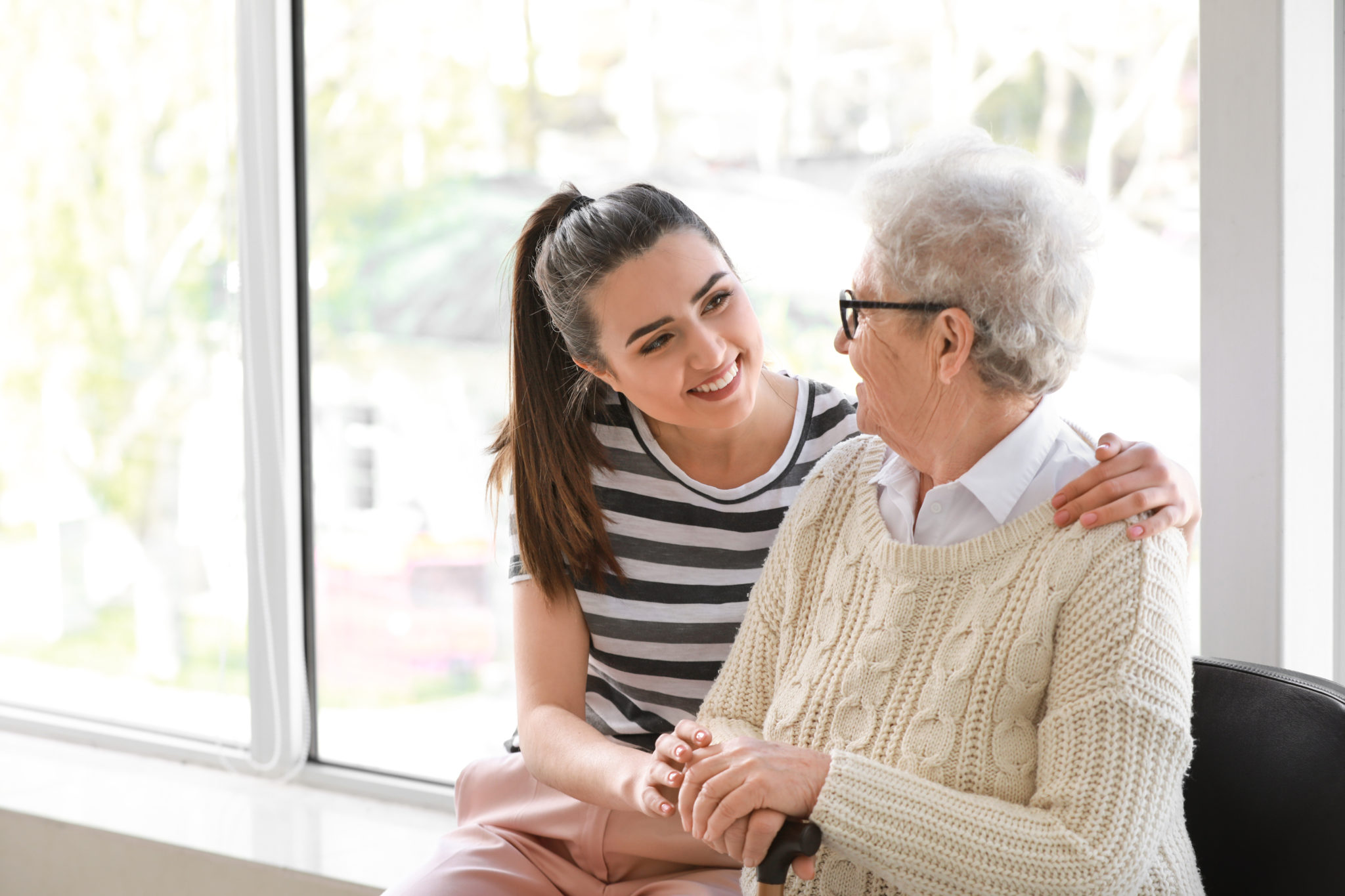 Young woman taking care of a senior woman