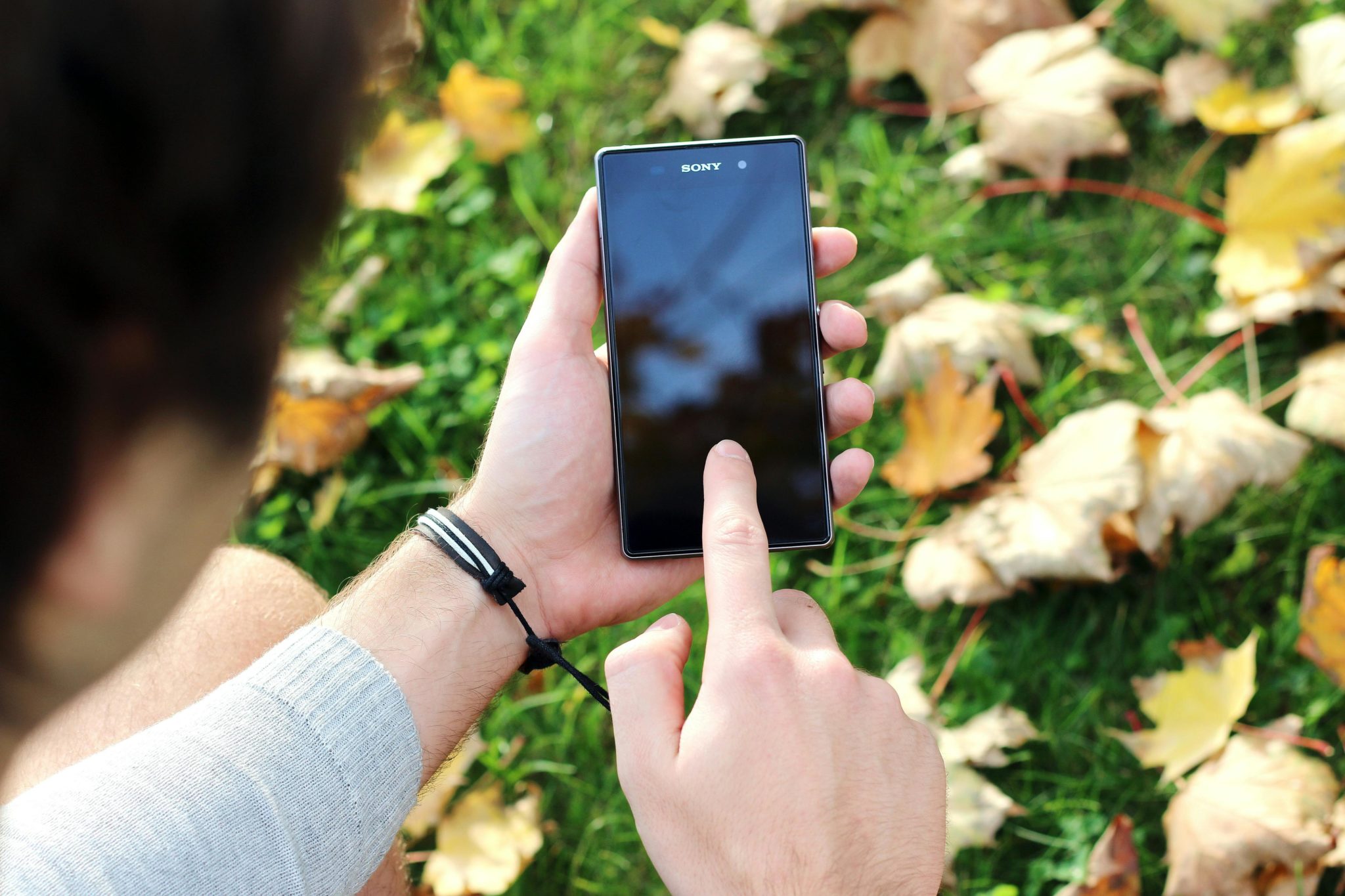 Frau schaut auf das Handy in der Natur.