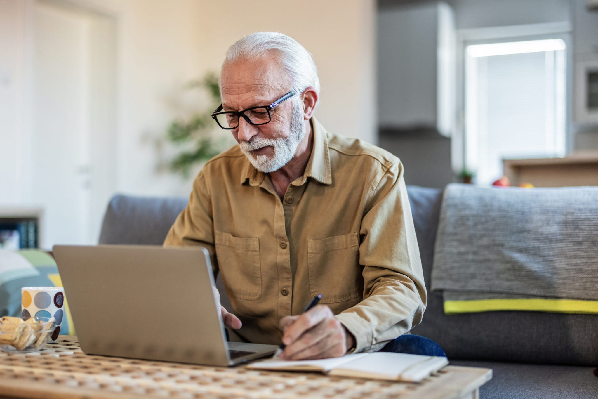 Senior man working with financial papers at home. Elderly man working on monthly expenses accounts. Finances,