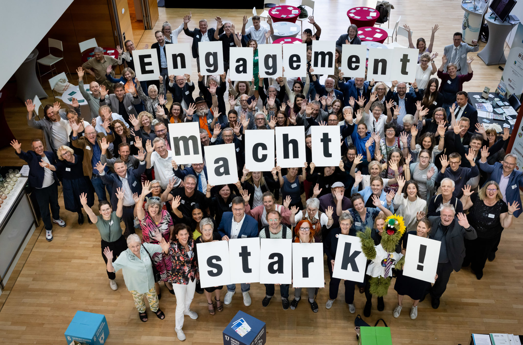 Menschengruppe hält Buchstaben hoch, die den Satz "Engagement macht strak" bilden.