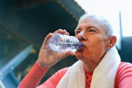 Älterer Sportler trinkt aus einer PET Flasche.
