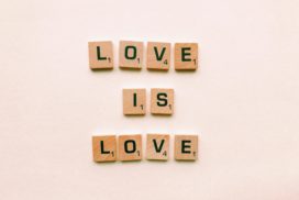 Man sieht Holzwürfel mit je einem Buchstaben drauf. Nebeneinander gelegt ergeben sie: Love is Love