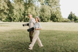 Man sieht eine Frau und einen Mann mit Yogamatten im Park