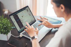 Man sieht eine Person etwas in eien Laptop tippen