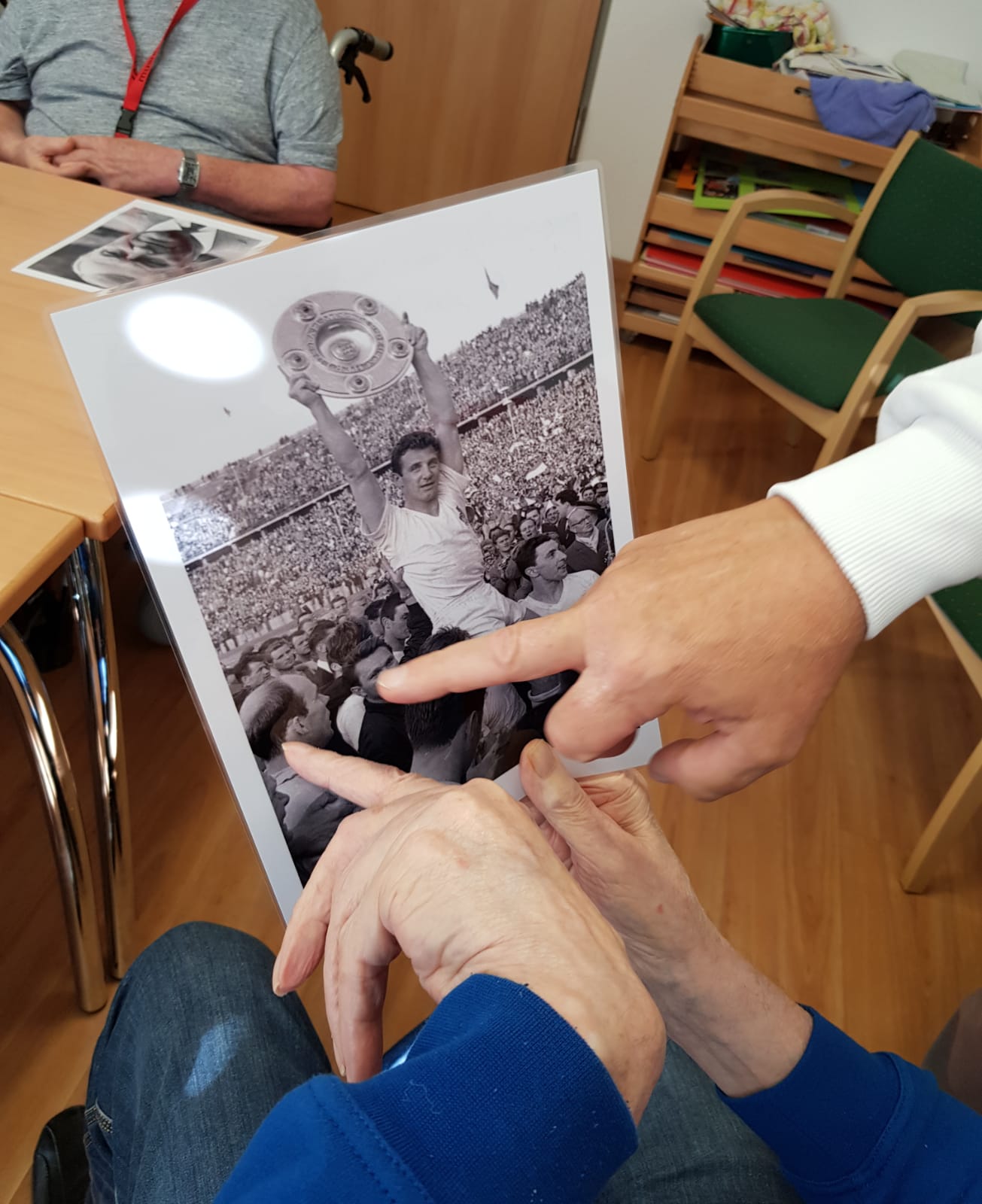 Zwei Menschen betrachten gemeinsam das Fotos eines Spielers