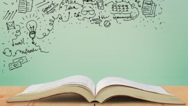 Ein offenes Buch liegt auf einem Tisch. In der linken