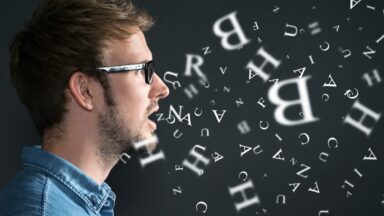 Eine Person spricht und aus ihrem Mund fliegen Buchstaben.