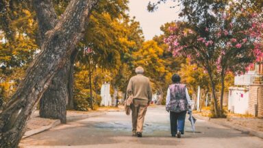 Zwei Senior*innen bei einem Herbstspaziergang.