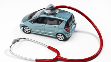 Ein Stetoskop ist auf ein Spielzeugauto gerichtet.