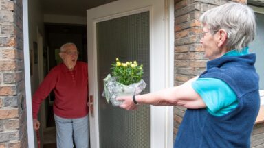 Einem Pflegenden Angehörigen werden Blumen überreicht.