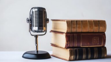 Mikrofon und gestapelte Bücher auf einem Tisch.