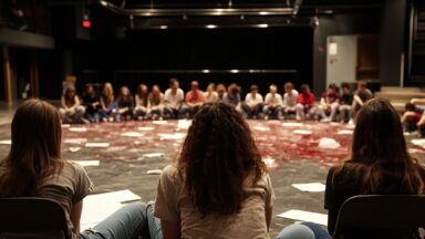 Personen in einem Sitzkreis von hinten zu sehen.