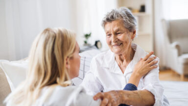 Eine junge Frau kümmert sich um eine ältere Frau.