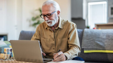 Senior man working with financial papers at home. Elderly man working on monthly expenses accounts. Finances