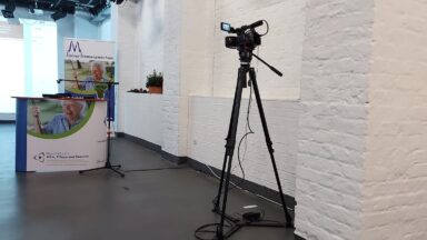 Kamera ausgerichtet auf Counter und RollUp der 8. Kölner Demenzwochen