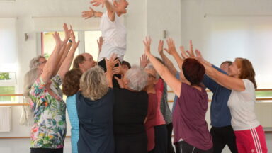 Gruppe von Menschen streckt die Arme in die Höhe