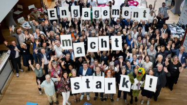 Menschengruppe hält Buchstaben hoch