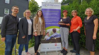 Die 6 Mitarbeitenden des Regionalbüros Südwestfalen stehen links und rechts neben einem Rollup des Regionalbüros