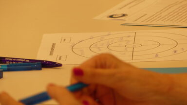 Hände einer Teilnehmerin mit Stift