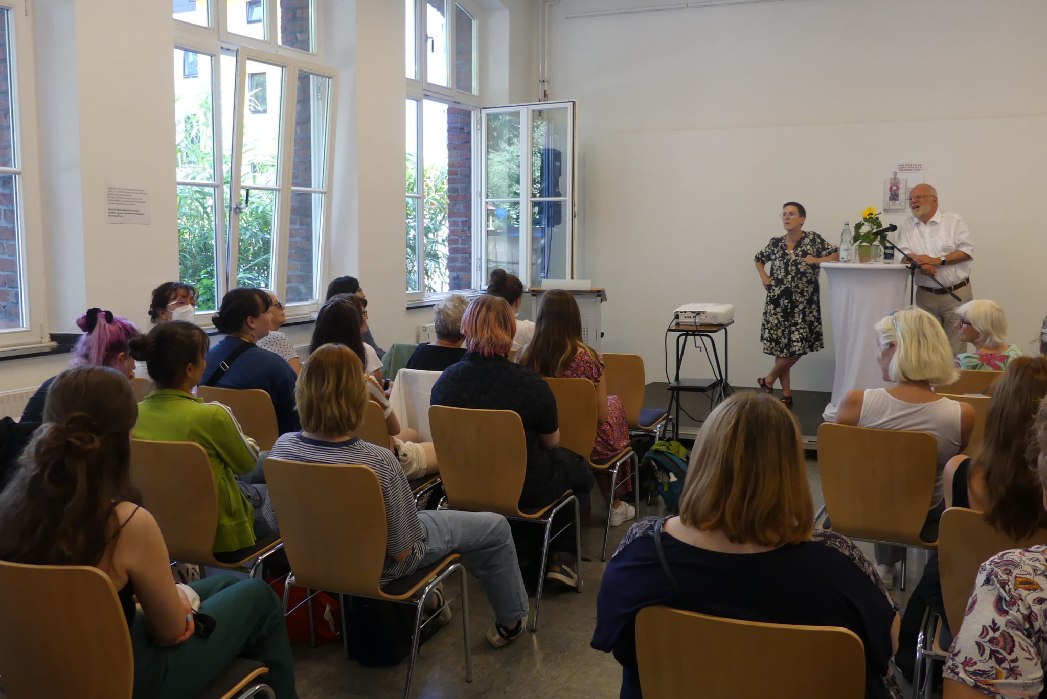 Blick über das Plenum auf die Bühne, wo gerade die Podiumsdiskussion stattfindet