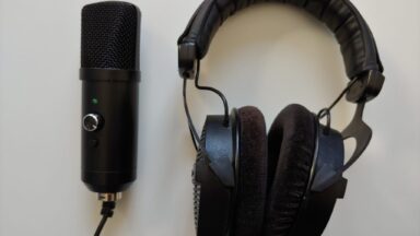 Ein Mikrofon und ein Kopfhörer liegen nebeneinander auf dem Tisch