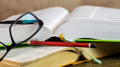 Auf einem Tisch liegen zwei aufgeschlagene Bücher