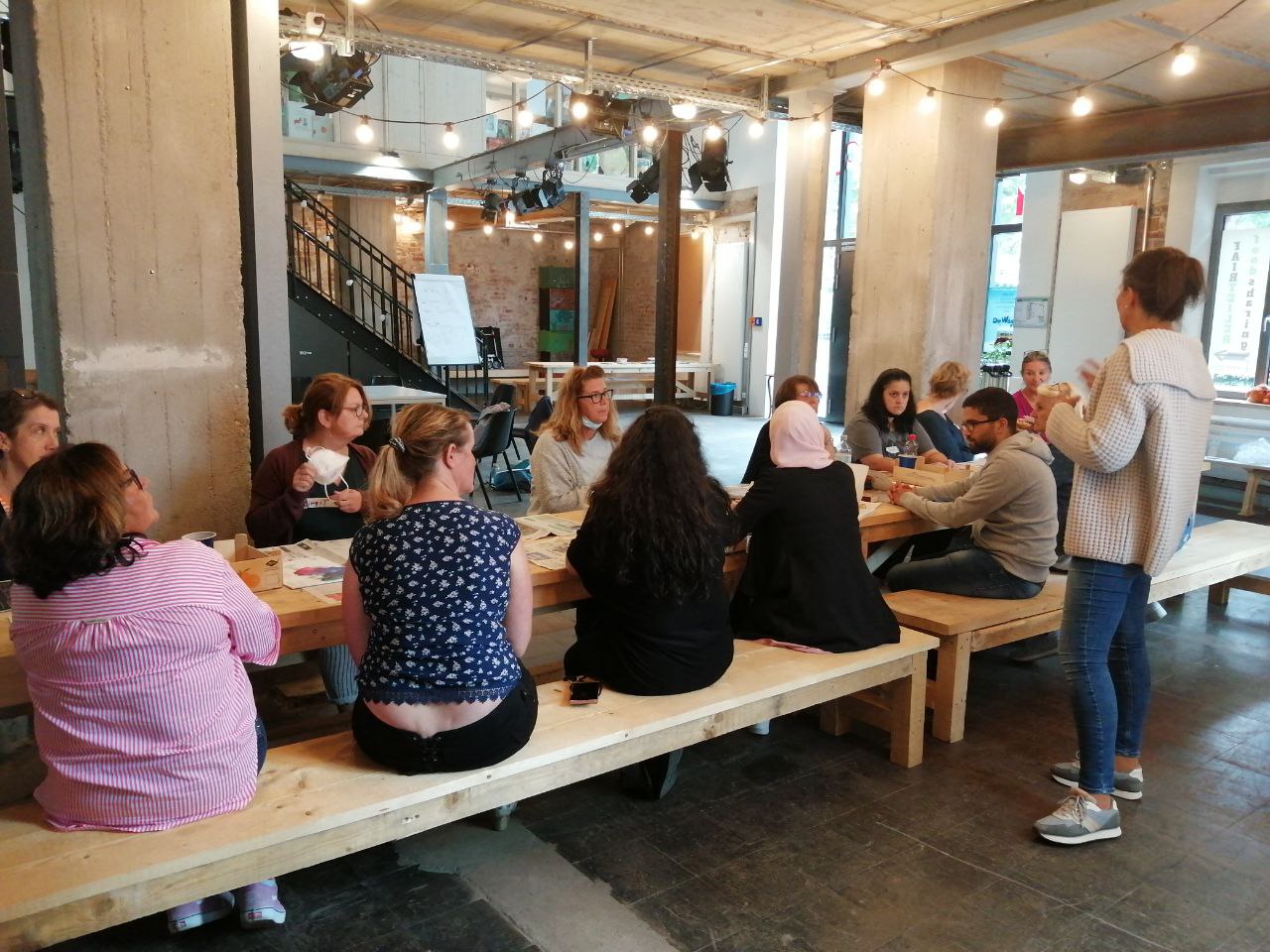 Teilnehmende am Tisch im Praxisimpuls "kreatives Gestalten"